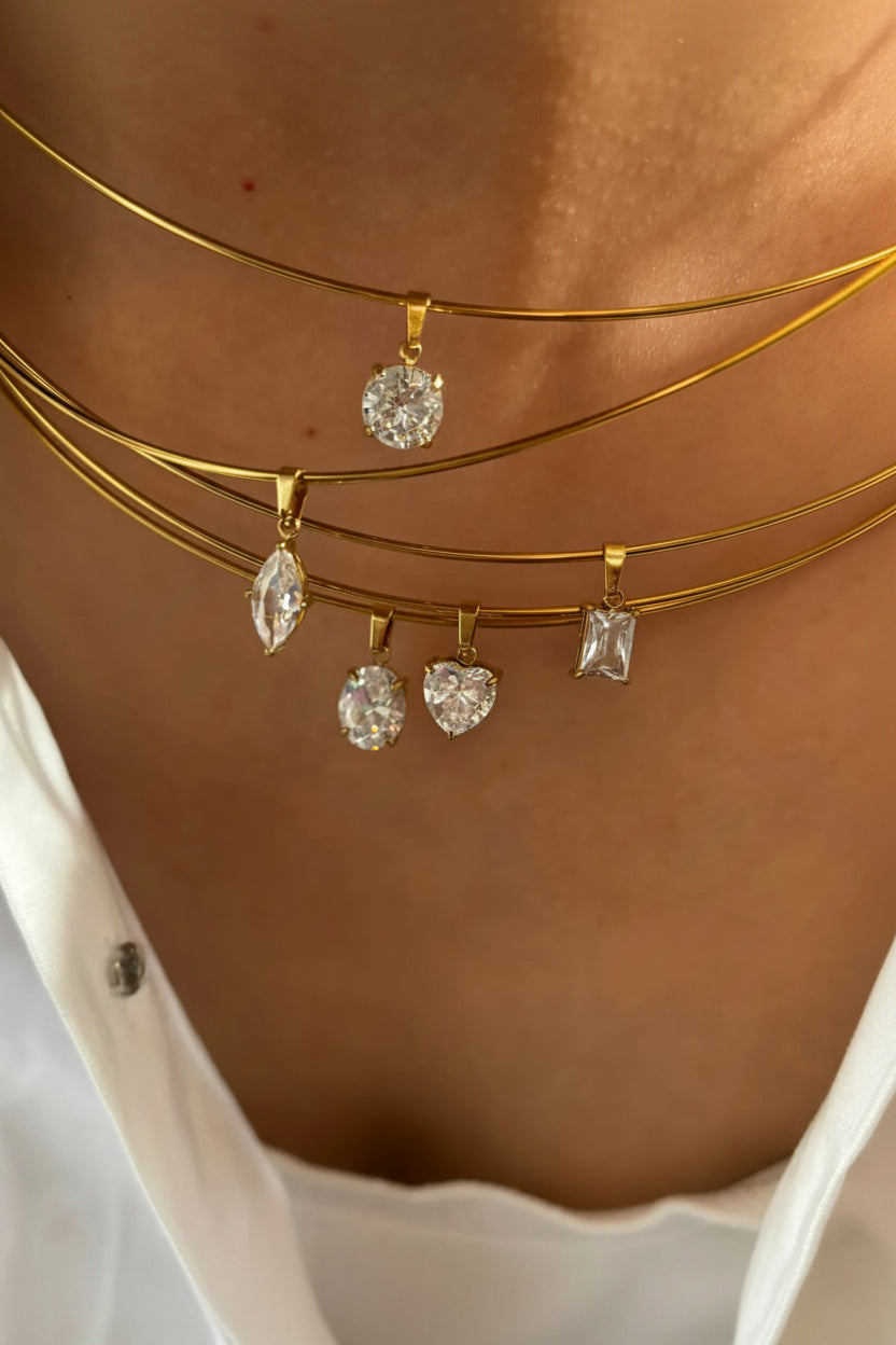 Gold necklaces with diamond pendants on a person's neck
