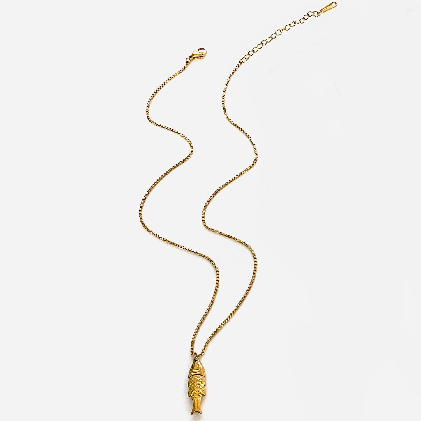 Gold necklace with a fish pendant on a white background